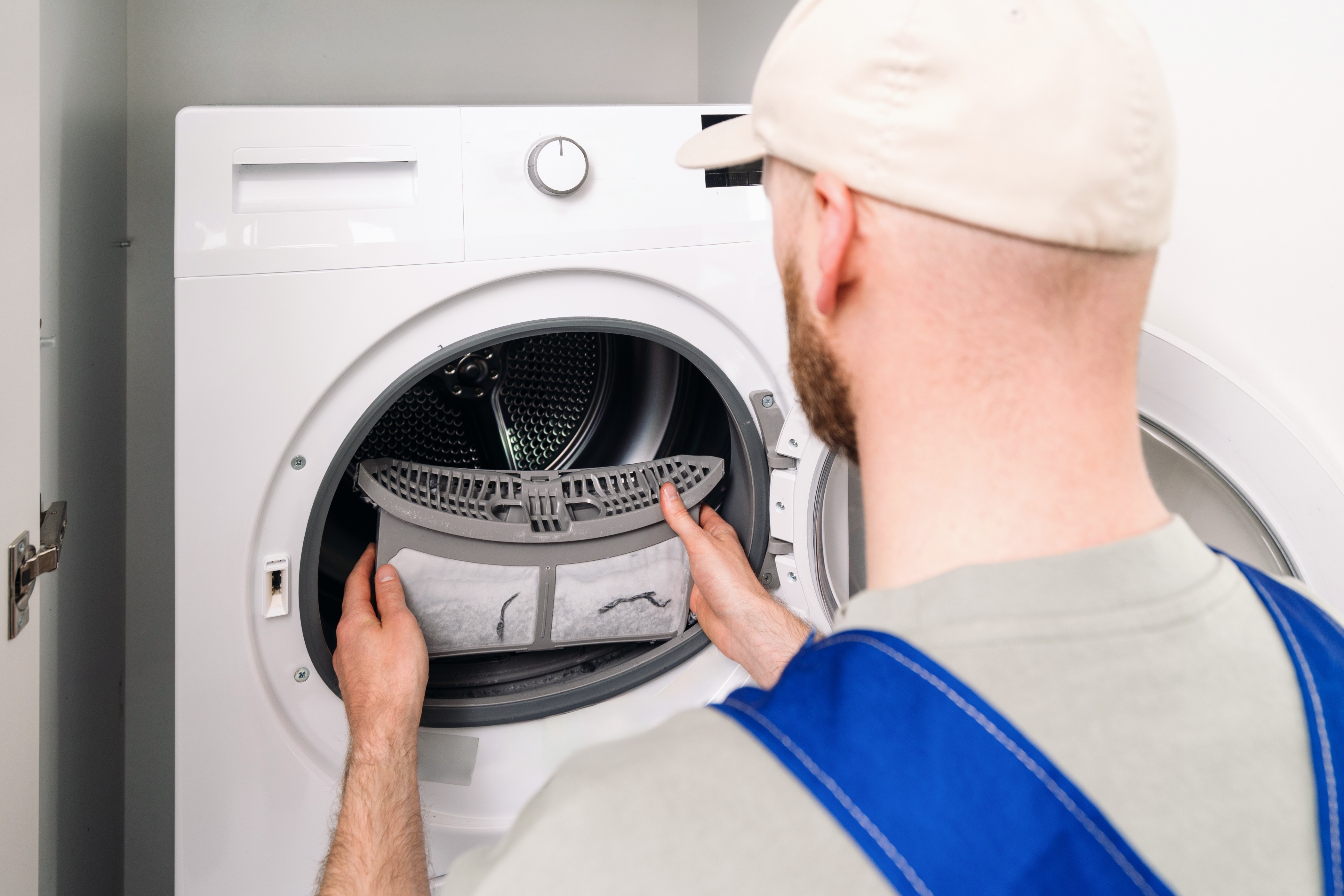 Technician cleaning a dryer lint filter